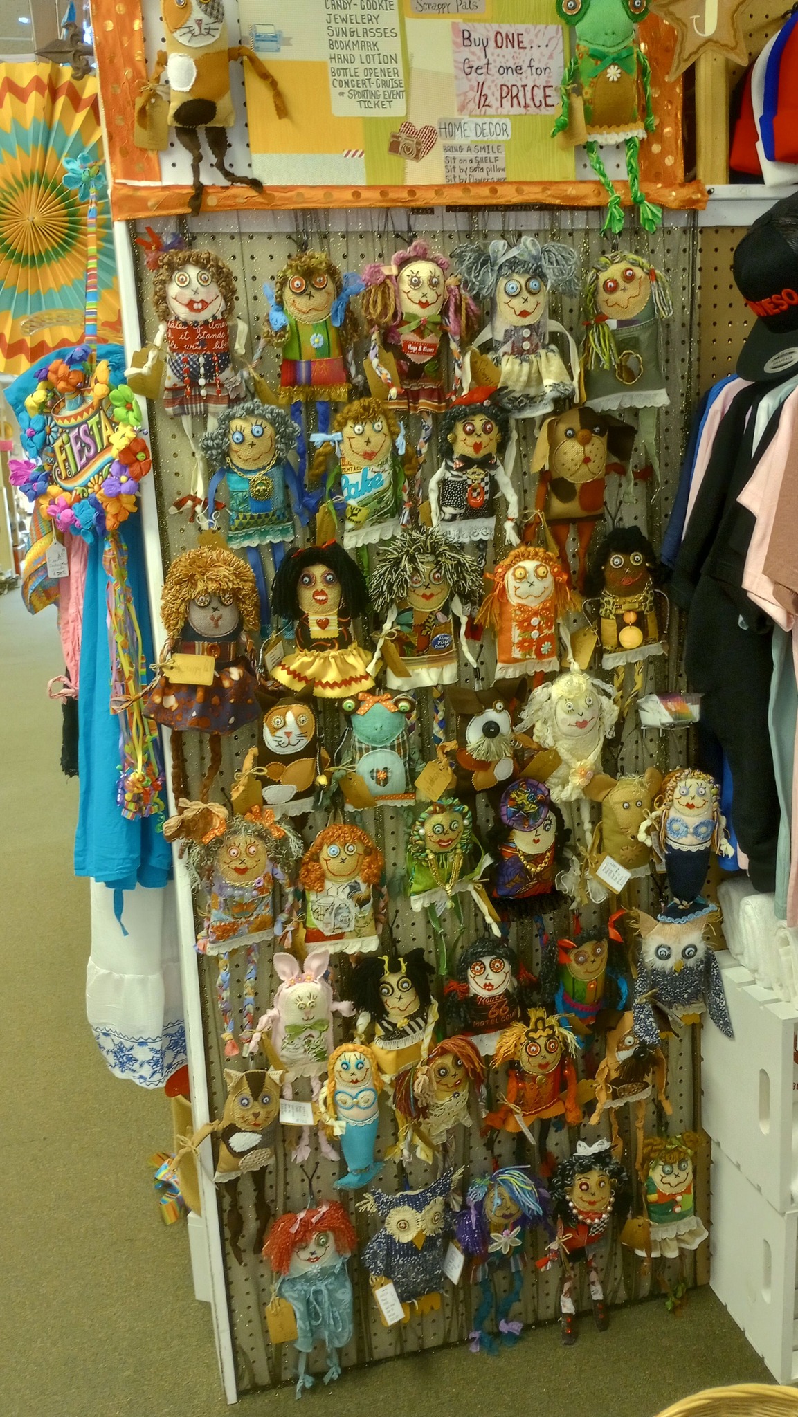 A wall display of dozens of handmade Scrappy Dolls by Kanda Kay, each one one-of-a-kind